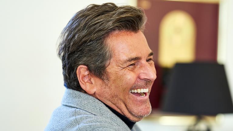 Der Sänger Thomas Anders lächelt bei einem Gespräch mit der Deutschen Presse Agentur in seinem Büro.