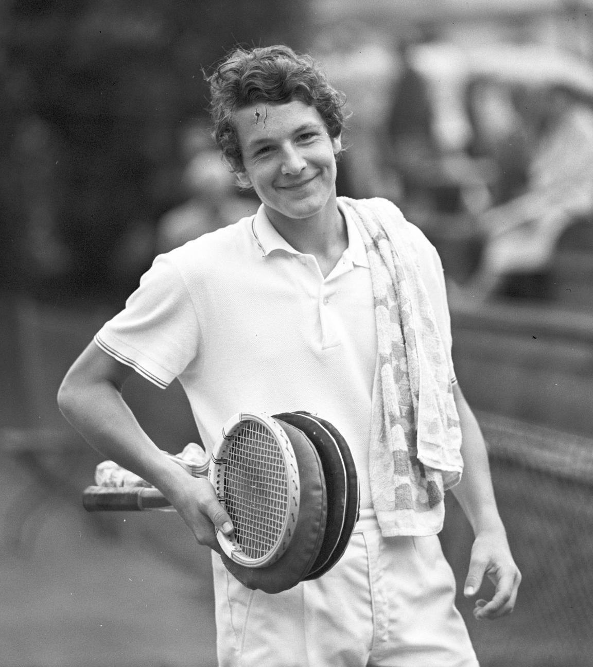 Tennisspieler Thomas Emmrich lächelnd, mit ein paar Tennisschlägern in der Hand.