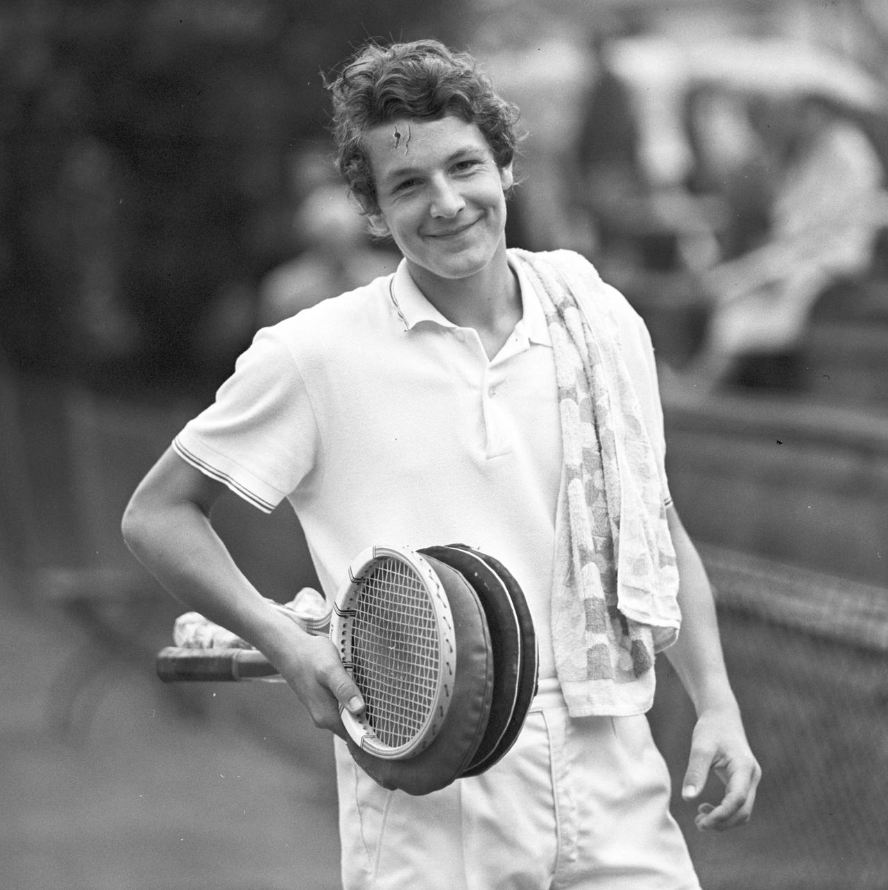 Tennisspieler Thomas Emmrich lächelnd, mit ein paar Tennisschlägern in der Hand.