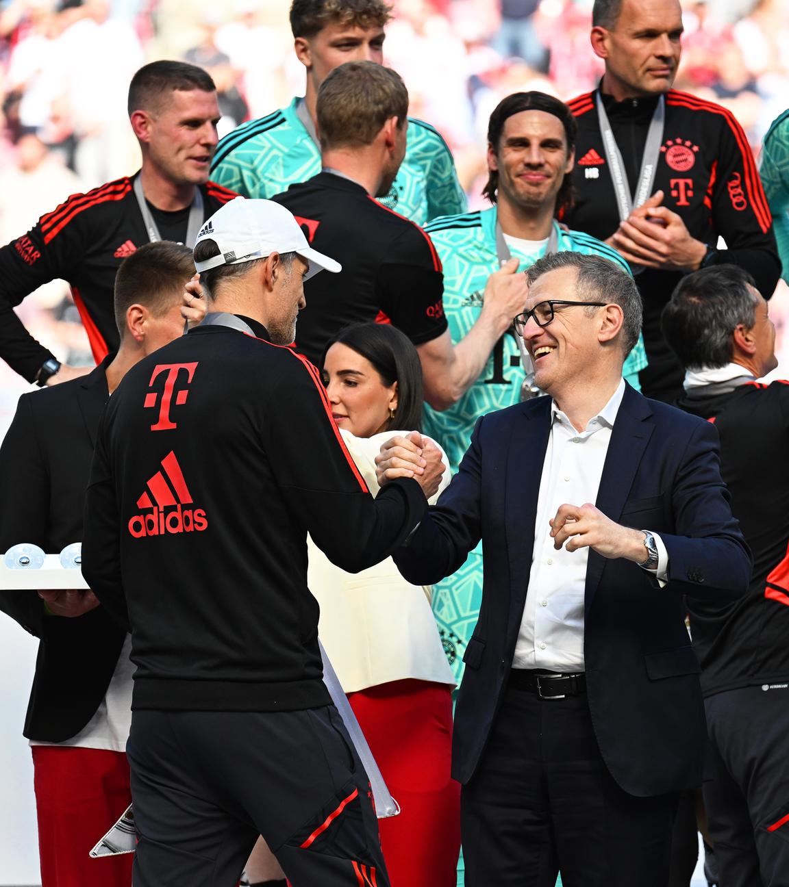 27.05.2023, Nordrhein-Westfalen, Köln: Fußball: Bundesliga, 1. FC Köln - Bayern München, 34. Spieltag, RheinEnergieStadion. Bayerns Trainer Thomas Tuchel (Mitte l) wird von Jan-Christian Dreesen, DFL Finanzvorstand, zum Gewinn der 33. deutschen Meisterschaft gratuliert. 