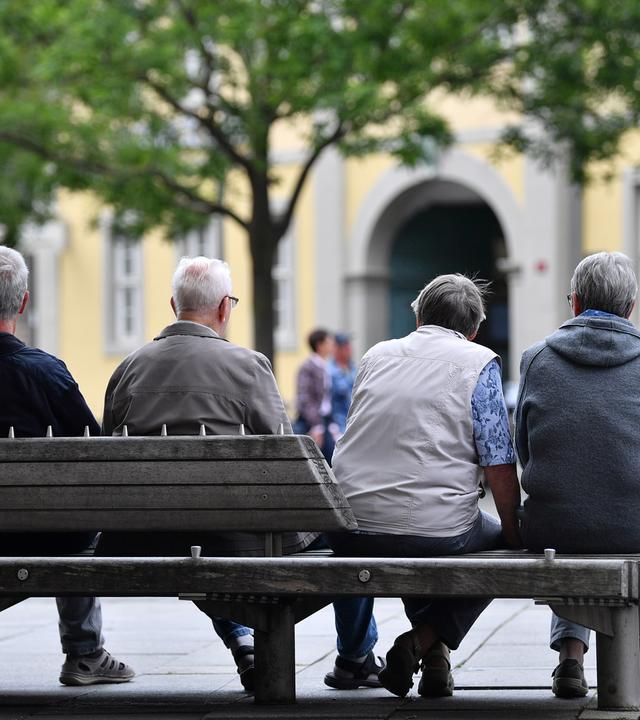 Thüringen, Erfurt: Vier ältere Menschen sitzen zusammen auf einer Bank
