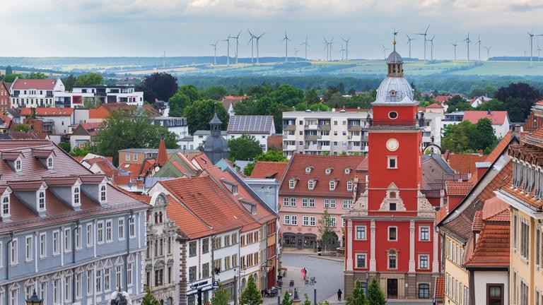 Blick vom Schloss Friedenstein auf die Altstadt von Gotha mit den historischen Rathaus. Im Hintergrund Windräder. 