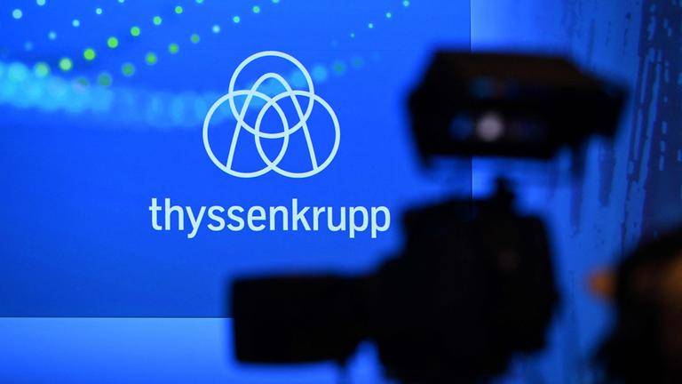 Symbolbild: Während der jährlichen Pressekonferenz des deutschen Industrieriesen Thyssenkrupp am 19. 11. 2024 in seinem Hauptsitz in Essen ist eine Fernsehkamera vor einer Wand mit dem Firmenlogo zu sehen. 
