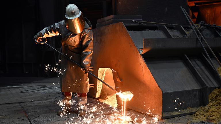 Ein Stahlarbeiter steht an einem Hochofen von Thyssenkrupp Steel.