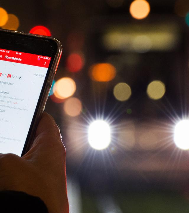 Symbolbild: Eine Frau hält an einem Strassenbahnsteig in Düsseldorf (nordrhein-westfalen) ein Smartphone in der hand. 