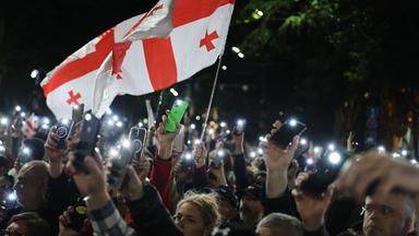 Georgien, Tiflis: Demonstranten mit einer georgischen Nationalfahne nehmen an einer Kundgebung der Opposition anlässlich des Unabhängigkeitstages teil