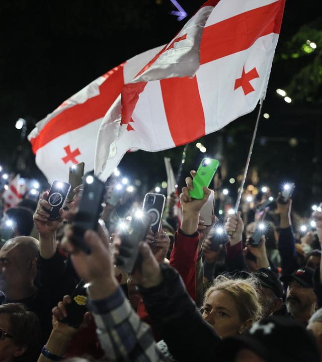 Georgien, Tiflis: Demonstranten mit einer georgischen Nationalfahne nehmen an einer Kundgebung der Opposition anlässlich des Unabhängigkeitstages teil