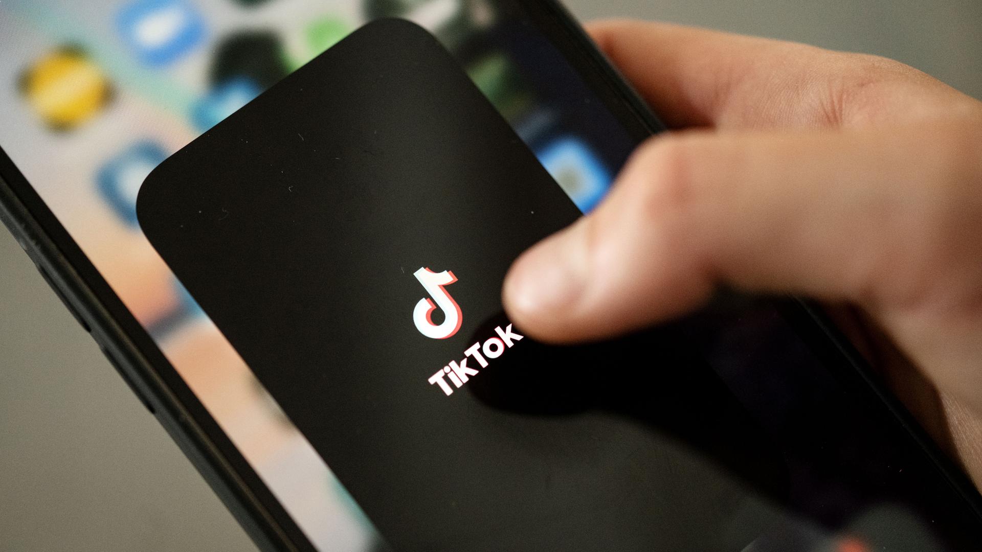 Archiv:  Ein Teenager tippt auf das TikTok-Logo auf einem Smartphone.