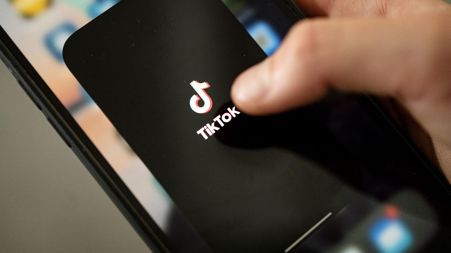 Archiv:  Ein Teenager tippt auf das TikTok-Logo auf einem Smartphone.