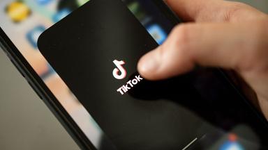 Archiv:  Ein Teenager tippt auf das TikTok-Logo auf einem Smartphone.