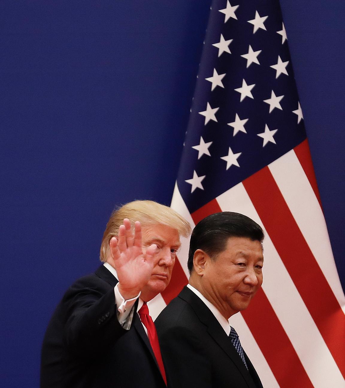 Der chinesische Präsidenten Xi Jinping (r) geht in der Großen Halle des Volkes zusammen mit dem US-Präsidenten Donald Trump am  09.11.2017 in Peking, China, an Nationalflaggen vorbei. 