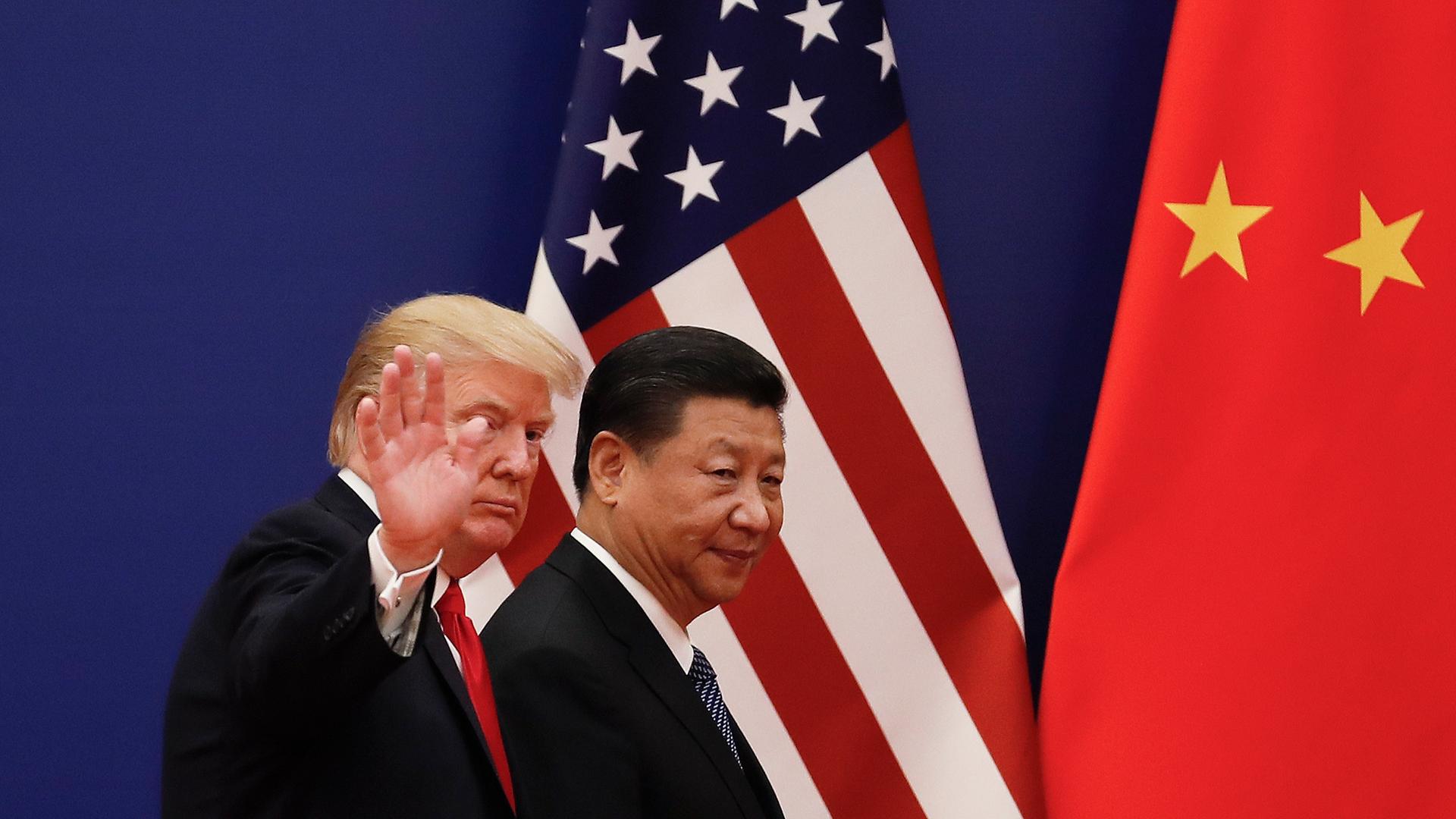 Der chinesische Präsidenten Xi Jinping (r) geht in der Großen Halle des Volkes zusammen mit dem US-Präsidenten Donald Trump am  09.11.2017 in Peking, China, an Nationalflaggen vorbei. 