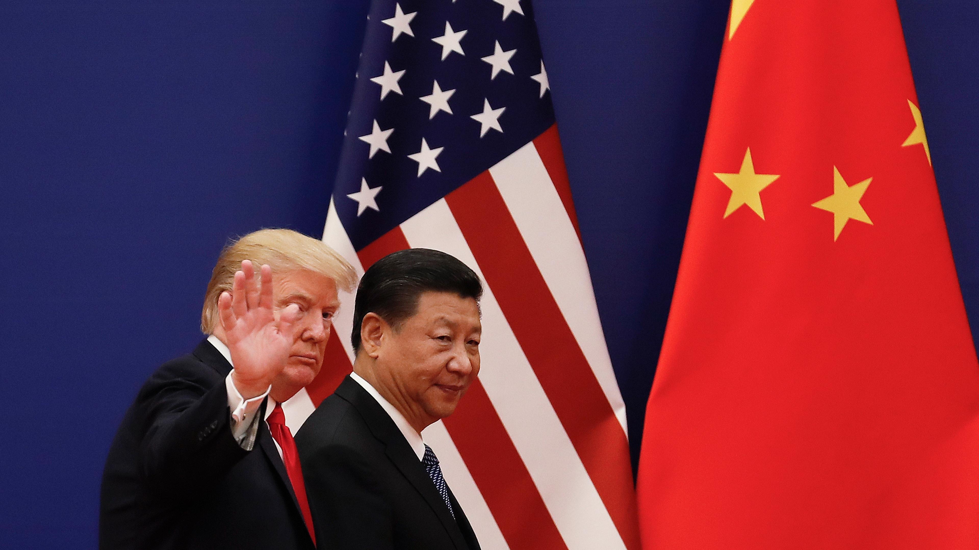 Der chinesische Präsidenten Xi Jinping (r) geht in der Großen Halle des Volkes zusammen mit dem US-Präsidenten Donald Trump am  09.11.2017 in Peking, China, an Nationalflaggen vorbei. 