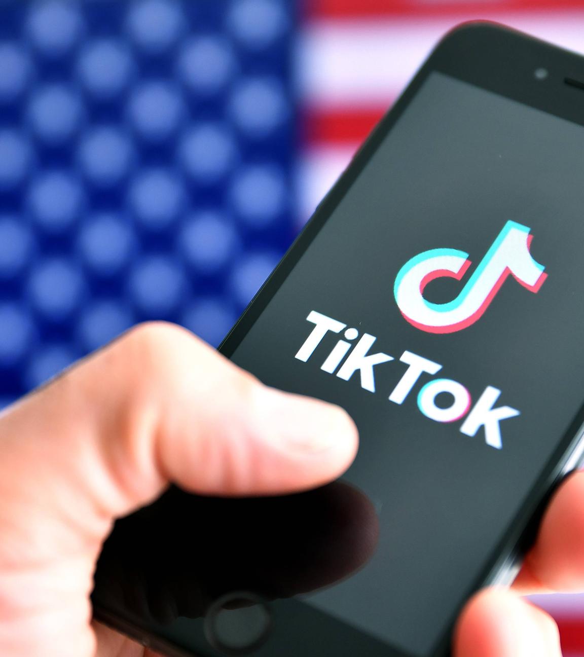 Symbolbild: TikTok-APP auf Smartphone vor USA-Flagge