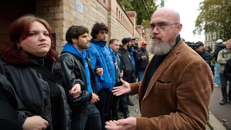 Vertreter der Jüdischen Studierendenunion Deutschlands versperren vor Hans-Thomas Tillschneider (AfD), stellvertretender Landtagspräsident in Sachsen-Anhalt, den Eingang zur Synagoge in Halle/Saale.