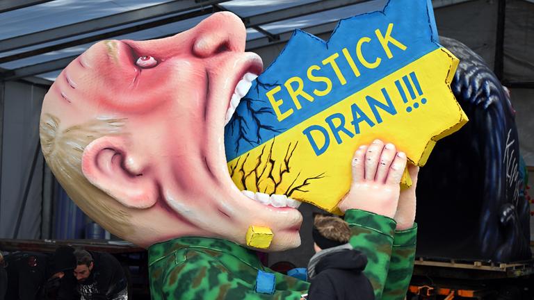 Ein Motivwagen mit dem russischen Präsidenten Putin, der die Ukraine schluckt, steht in der Wagenbauhalle. 