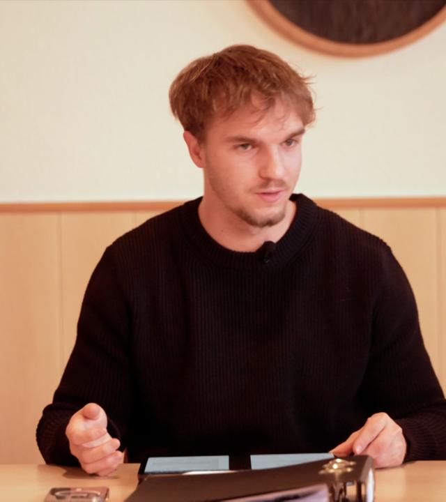 Tim Sieper, der ehrenamtliche Ortsbürgermeister von Eckenroth, sitzt an einem Tisch. Vor ihm liegt ein Ordner.