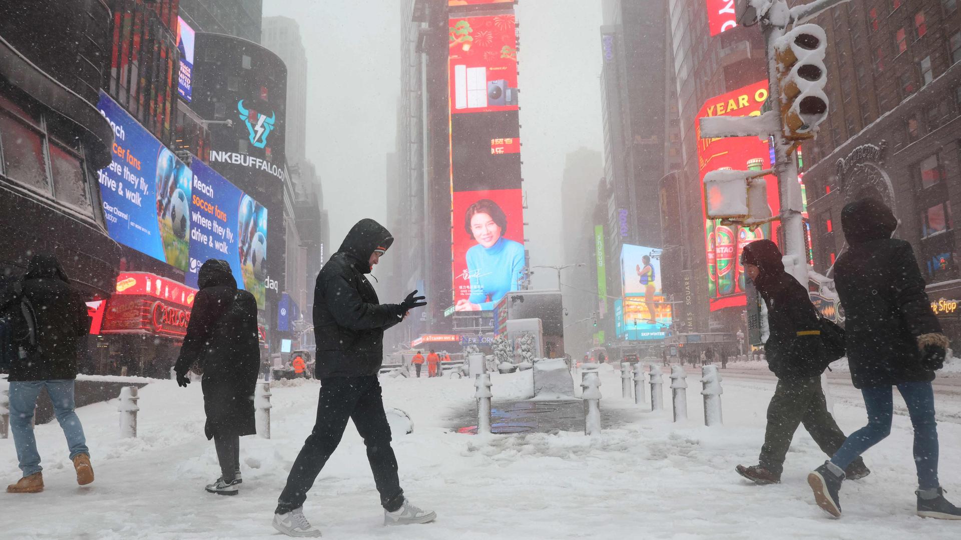 Menschen am Times Square in New York während des Schneesturms am 23.02.2026