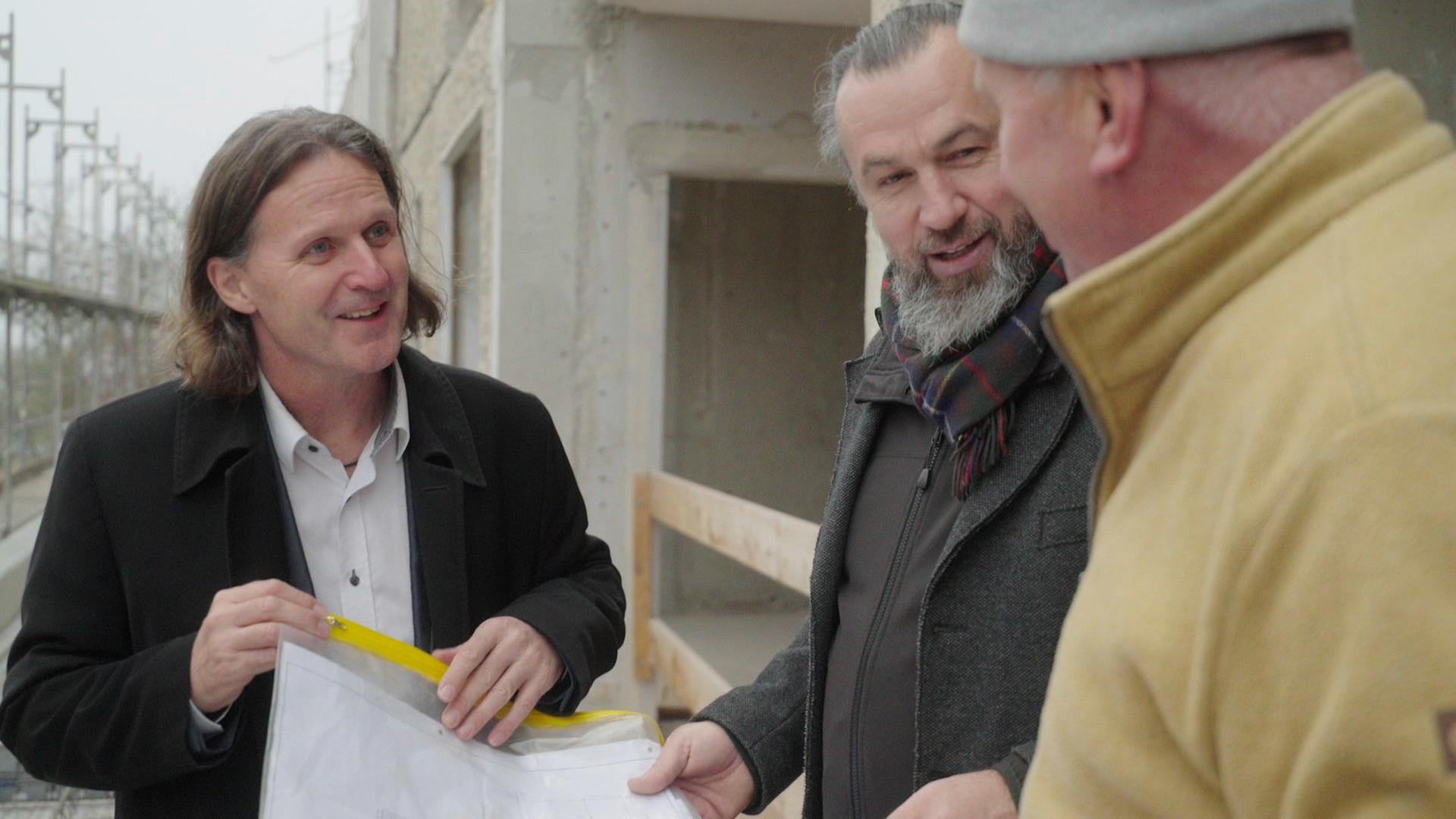 Timo Leukefeld zusammen mit Mike Eley, dem Geschäftsführer der Ascherslebener Gebäude- und Wohngesellschaft und Dieter Peters auf der Baustelle ihres gemeinsamen Projektes: energieautarken Plattenbauten