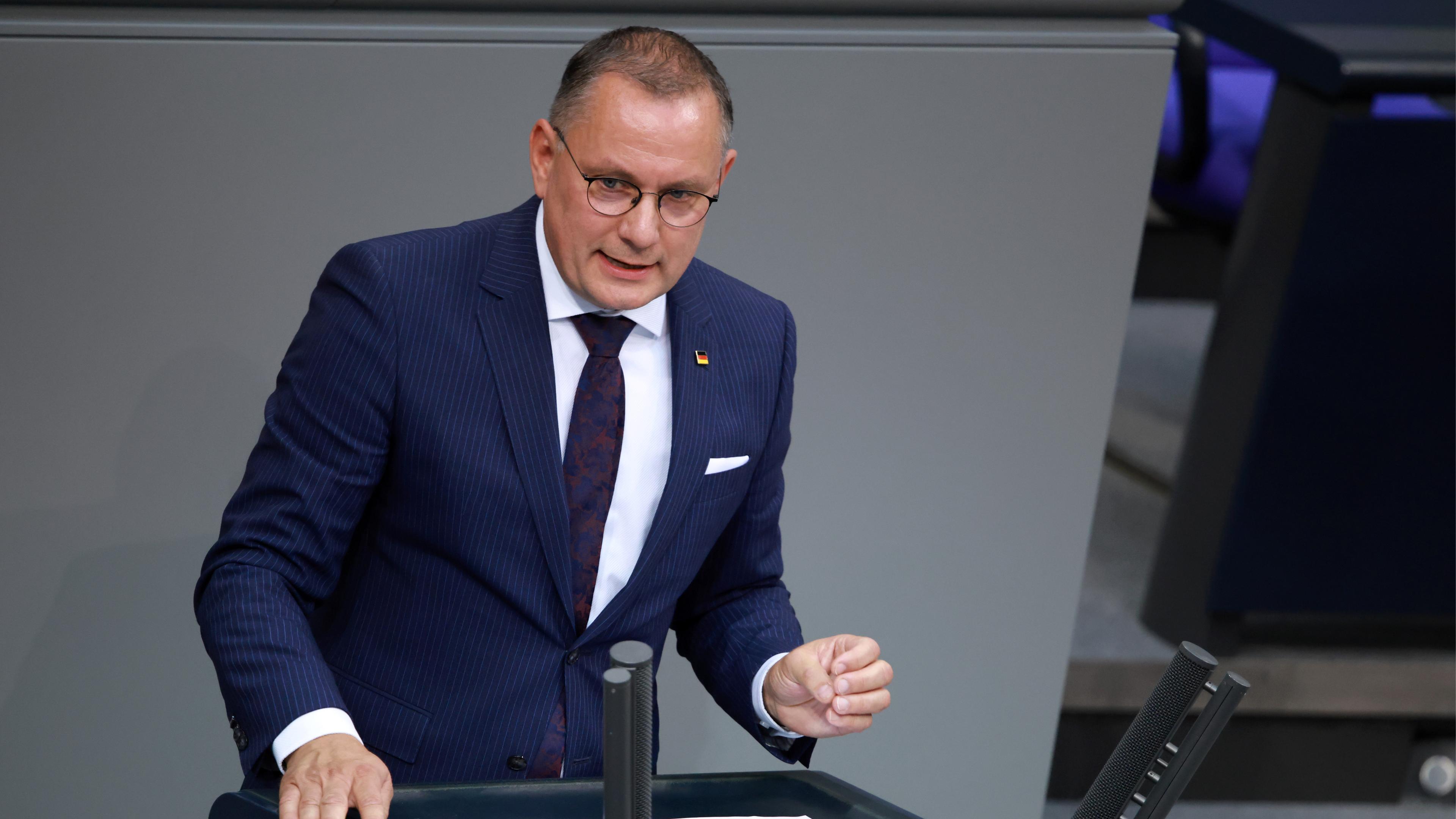 Tino Chrupalla im Bundestag. Er hält eine Rede am Rednerpult und gestikuliet dabei