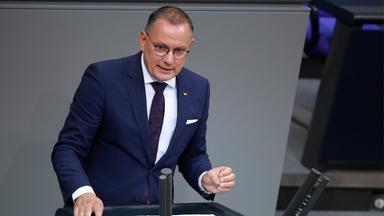 Tino Chrupalla im Bundestag. Er hält eine Rede am Rednerpult und gestikuliet dabei