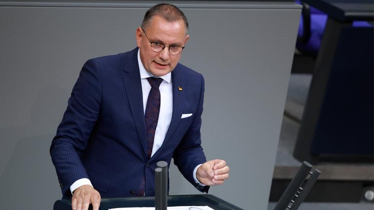 Tino Chrupalla im Bundestag. Er hält eine Rede am Rednerpult und gestikuliet dabei