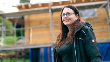 Lisa steht vor ihrem Tiny House, das noch im Bau ist.