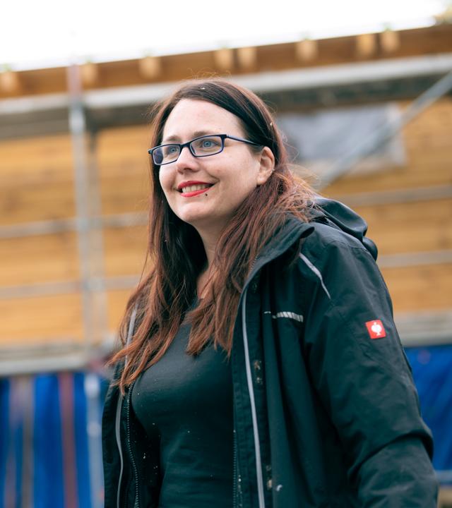 Lisa steht vor ihrem Tiny House, das noch im Bau ist.