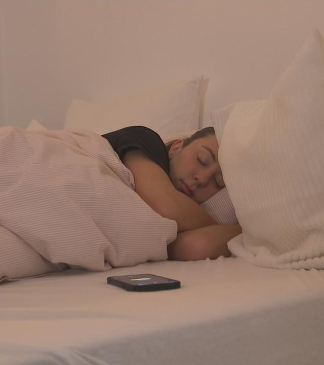 Jemand liegt im Bett und schläft.