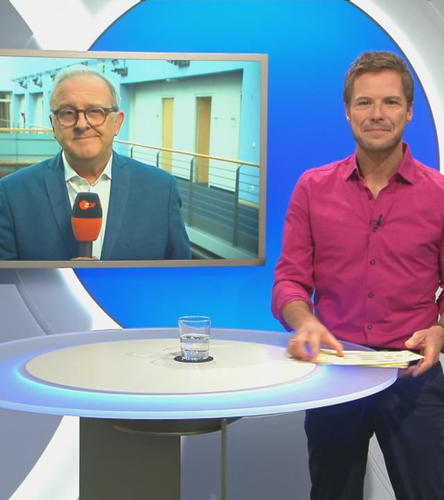 Florian Weiss im "Volle Kanne"-Studio, hinter ihm im Schaltgespräch auf dem Bildschirm Frank Bethmann zu sehen.