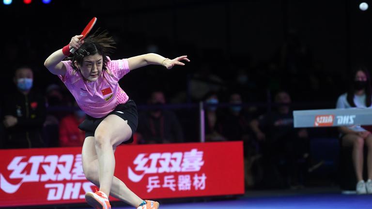 eine Tischtennisspielerin schlägt Ball zurück