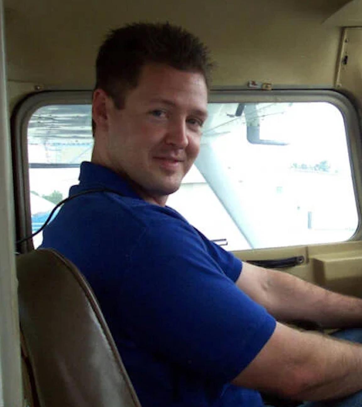 Schnappschuss von Todd Kohlhepp im Cockpit eines Flugzeugs: Er trägt ein blaues Polohemd und blickt in Richtung Kamera.