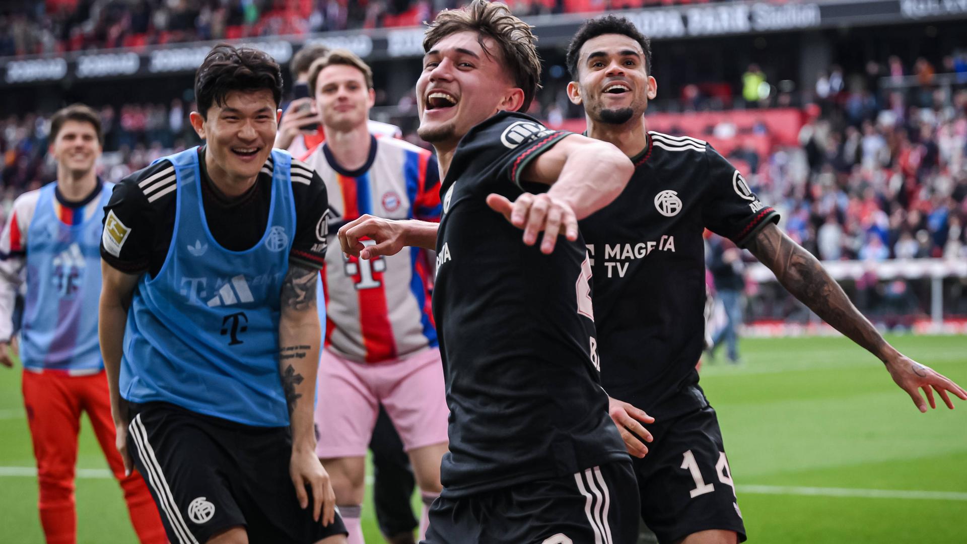 Min-Jae Kim, Tom Bischof, Torwart Jonas Urbig und Luis Diaz (v.li.) jubeln nach dem Schlusspfiff des Spiels gegen Freiburg