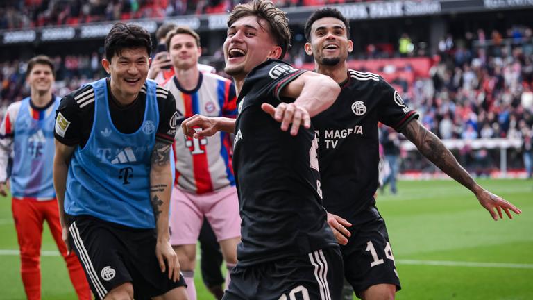 Min-Jae Kim, Tom Bischof, Torwart Jonas Urbig und Luis Diaz (v.li.) jubeln nach dem Schlusspfiff des Spiels gegen Freiburg