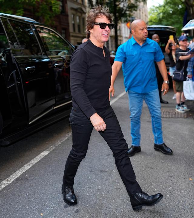 Auf dem Bild zu sehen ist Tom Cruise wie er läuft. Er trägt ein schwarzes Outfit mit dunkler Sonnebrille.