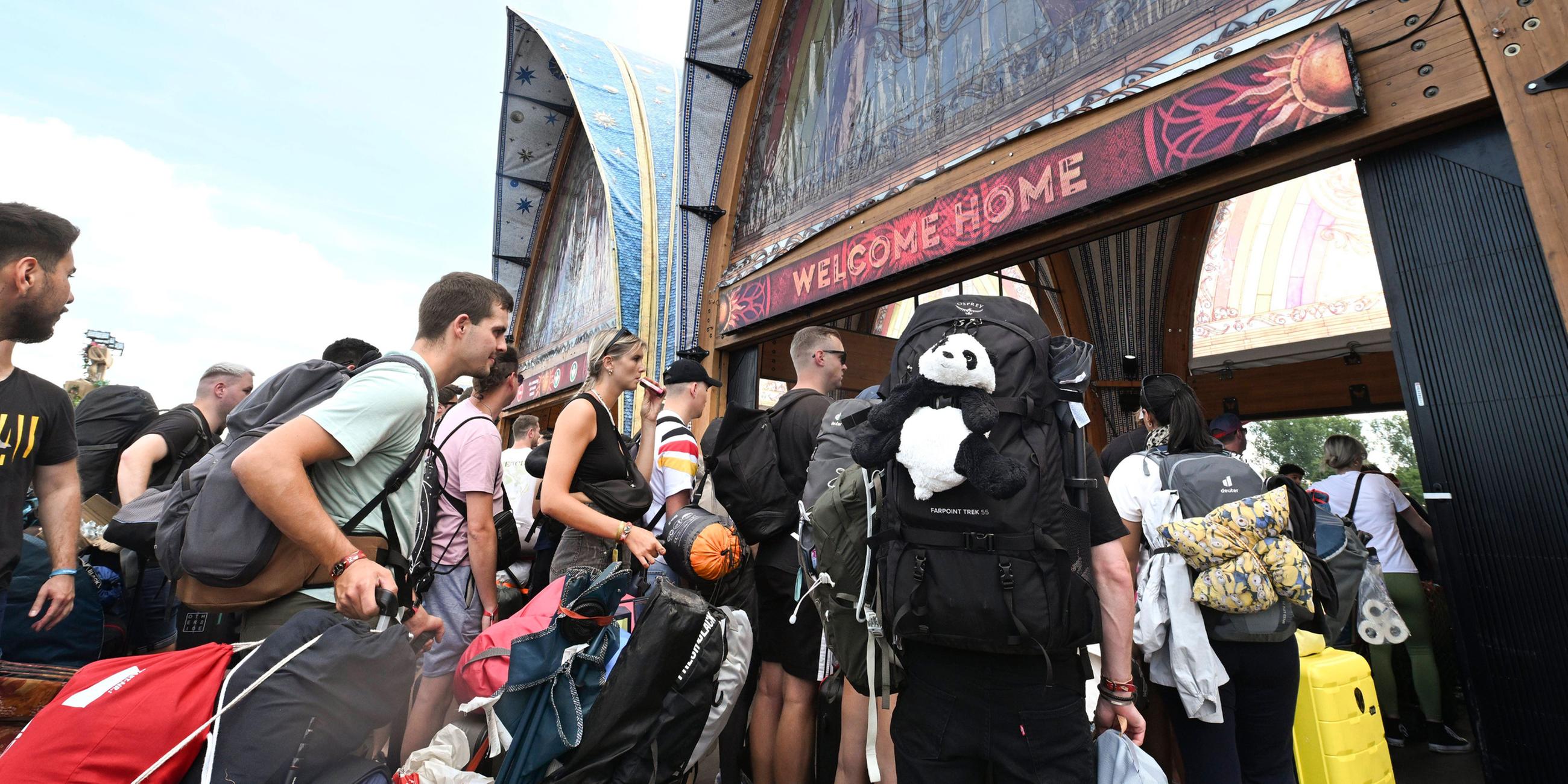 Besucher des Tomorrowland-Festivals in Belgien drängen durch den Eingang zur Hauptbühne des Festivals am 17.07.2025.