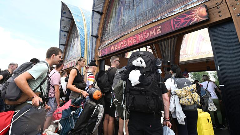 Besucher des Tomorrowland-Festivals in Belgien drängen durch den Eingang zur Hauptbühne des Festivals am 17.07.2025.