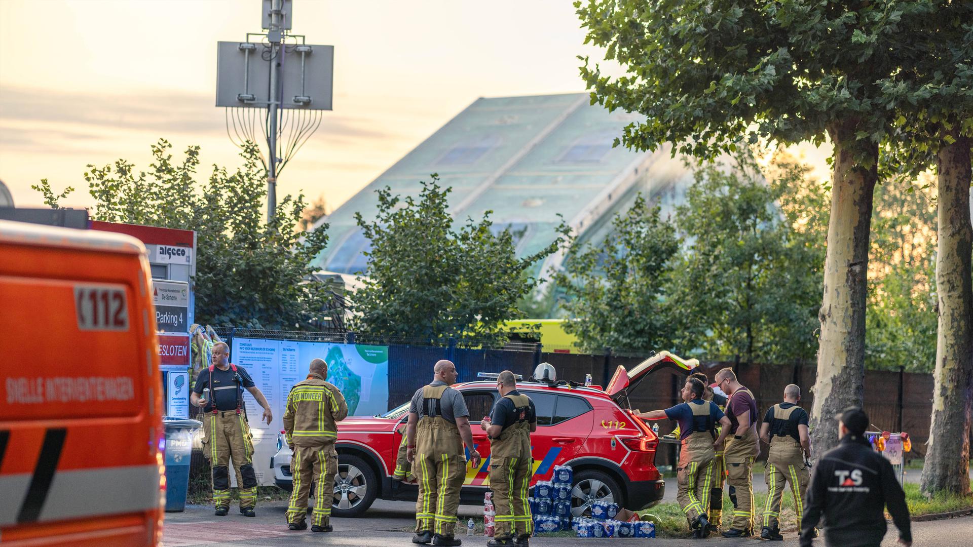 Feuerwehrleute stehen nach einem Großbrand in der Nähe des Tomorrowland-Geländes in Alarmbereitschaft. 