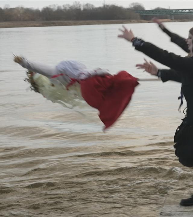 Eine Strohpuppe wird in einen Fluss geworfen