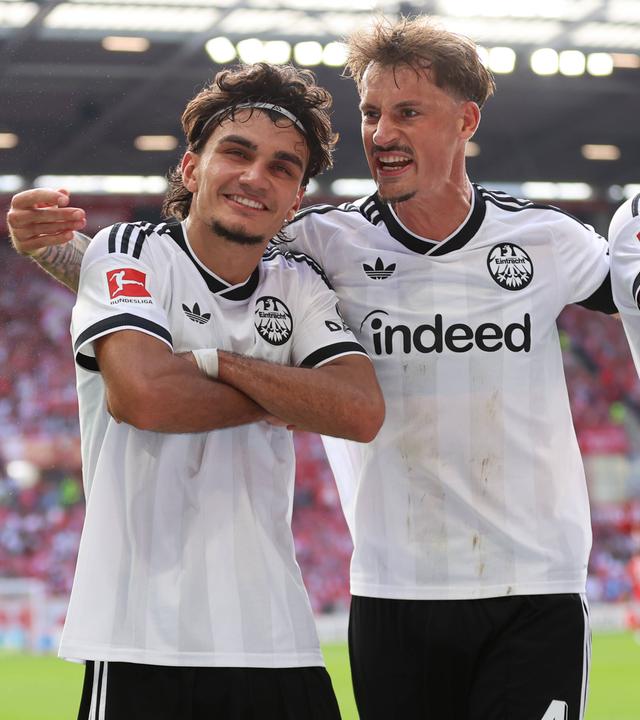 Frankfurts offensiver Mittelfeldspieler Can Uzun jubelt zusammen mit seinen Teamkameraden Robin Koch und Jeremiaha Maluze nach seinem Treffer zum 3:0