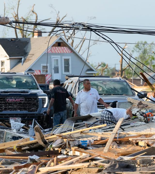 Nach einem Tornado am Montag, dem 27. Juli 2026, in Menasha, Wisconsin, sind Menschen damit beschäftigt, die Trümmer zu beseitigen.