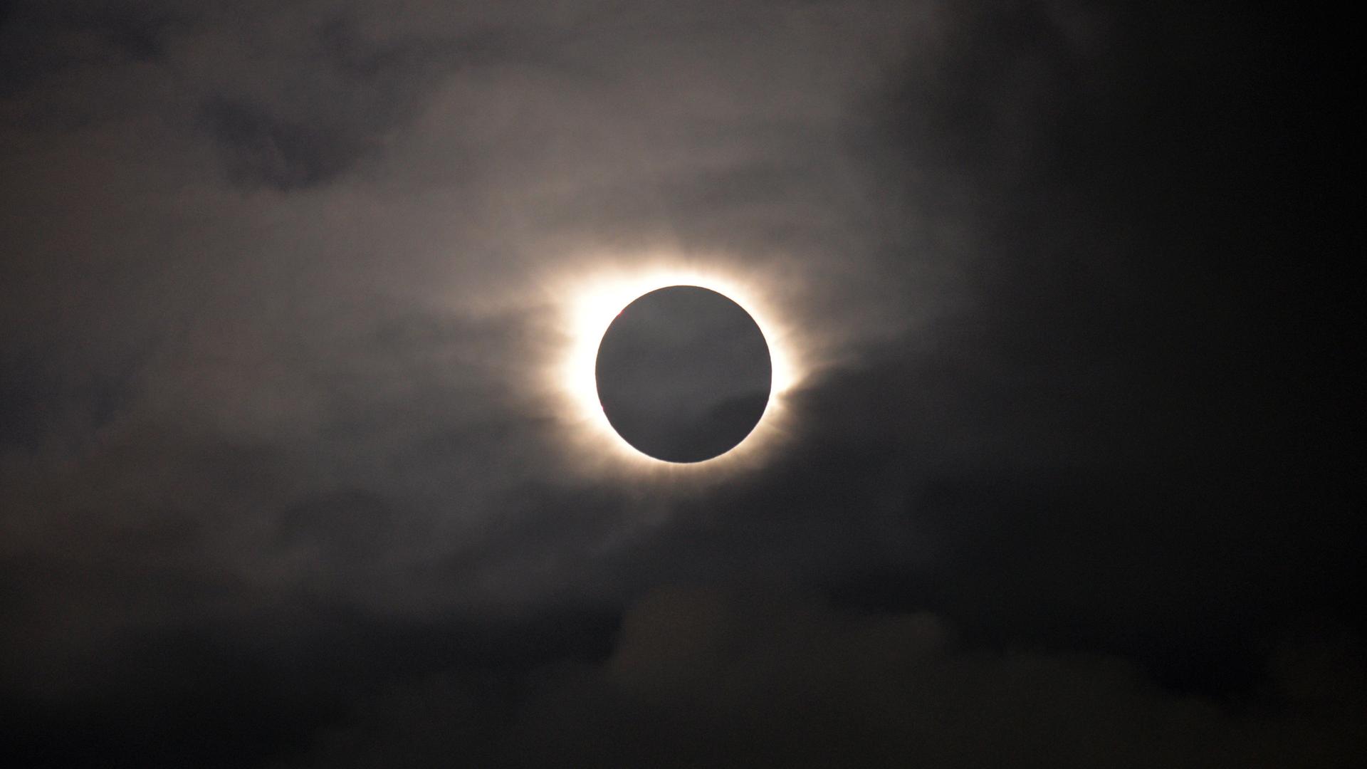 Der Mond schiebt sich bei einer Sonnenfinsternis über die Sonne.
