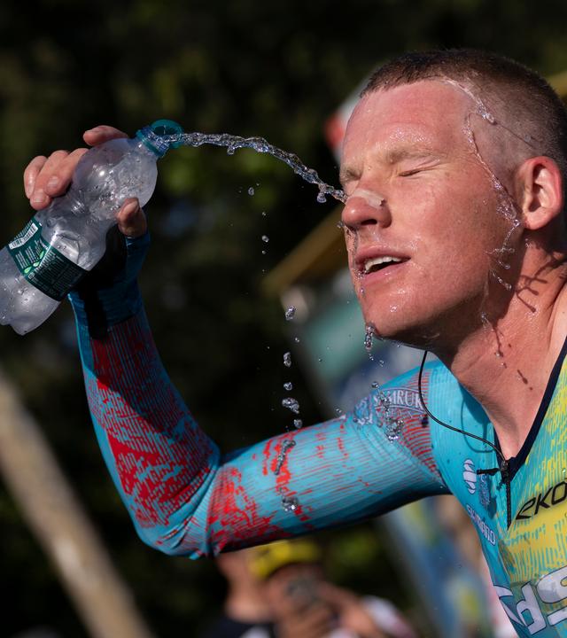 Ein Fahrer des Astana-Teams spritzt sich Wasser aus seiner Trinkflasche ins Gesicht