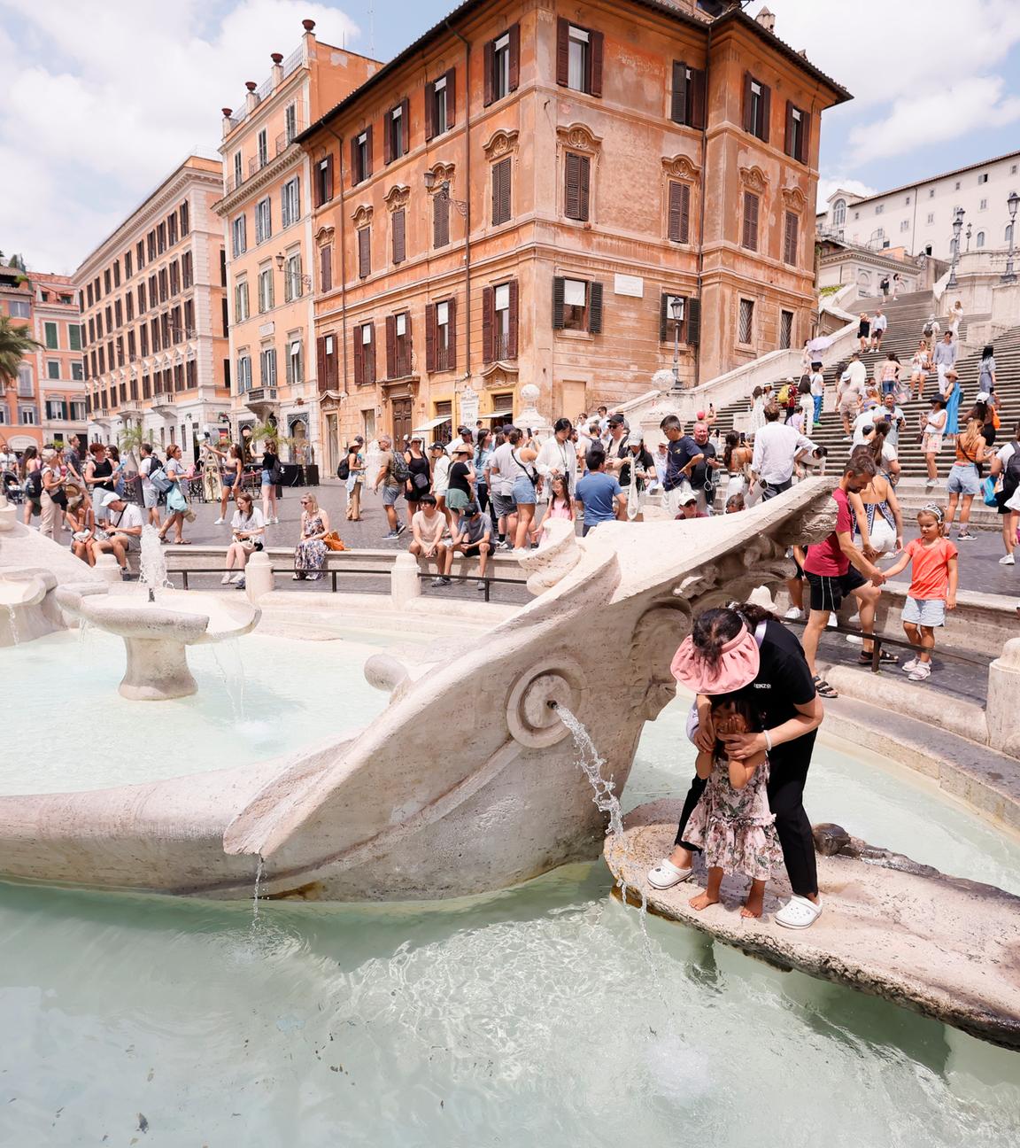 In Rom kühlen sich Touristen und Bewohner in einem Springbrunnen ab.