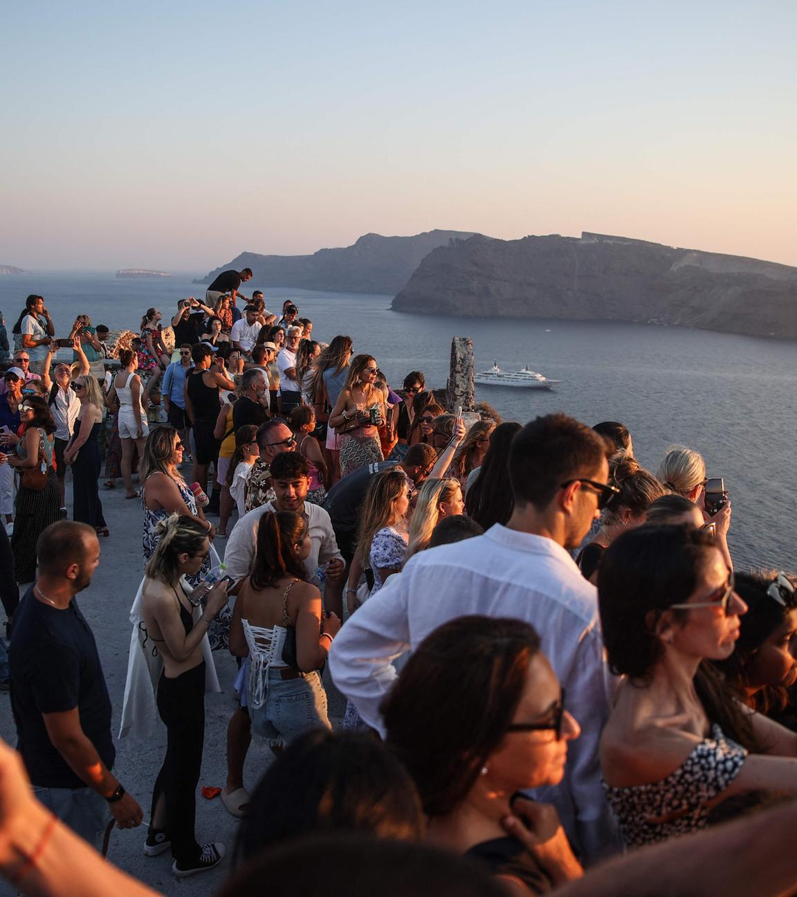 Symbolbild: Zahlreiche Touristen bei Sonnenuntergang auf Santorin
