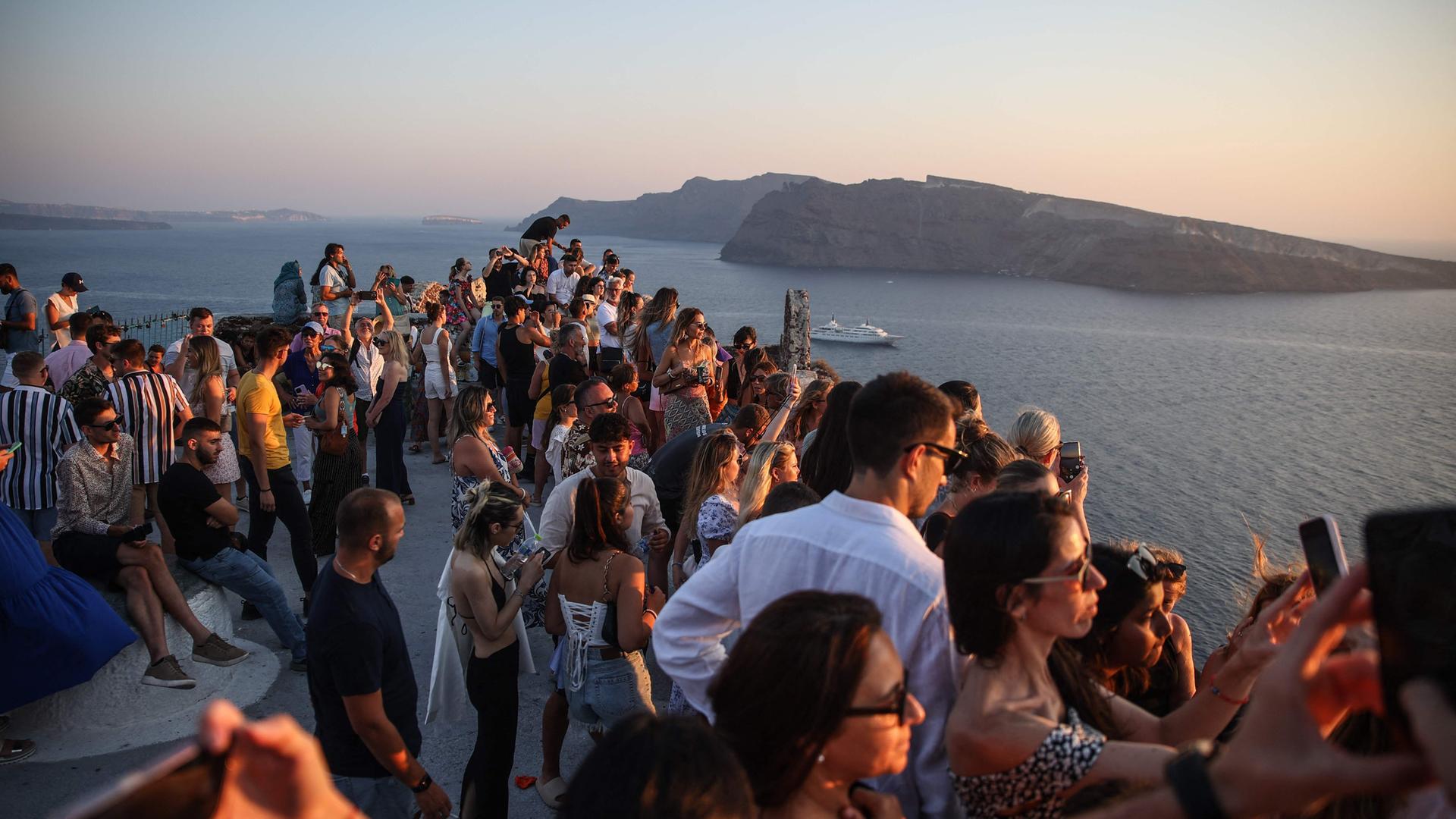 Symbolbild: Zahlreiche Touristen bei Sonnenuntergang auf Santorin