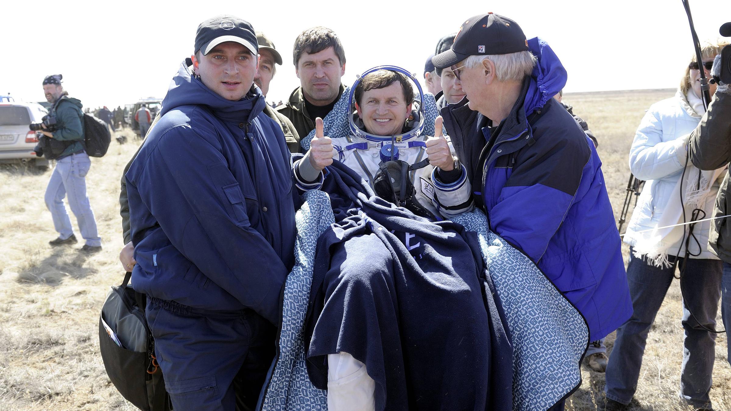 Archiv: Astronaut Charles Simonyi wird nach der Landung mit der Sojus TMA-13-Kapsel betreut, aufgenommen am 08.04.2009