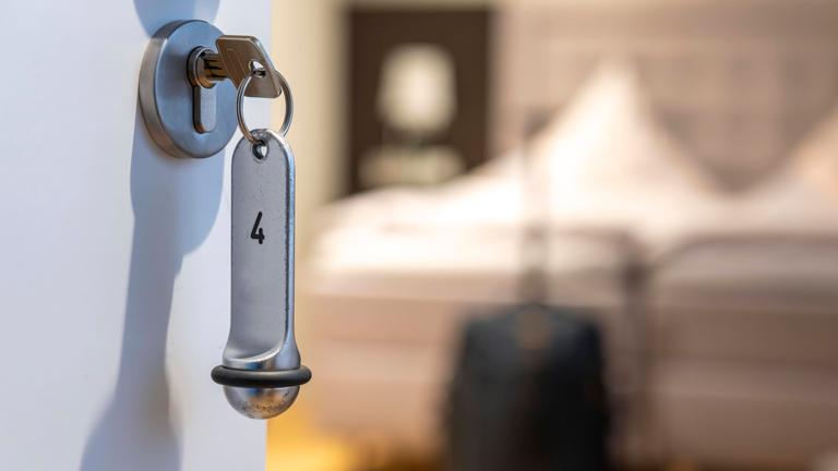 Der Schlüssel steckt in der Türe eines Hotelzimmers.