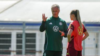 v.li. Bundestrainer Christian Wueck und Spielerin Marie Mueller sprechen miteinander auf dem Trainingsplatz.