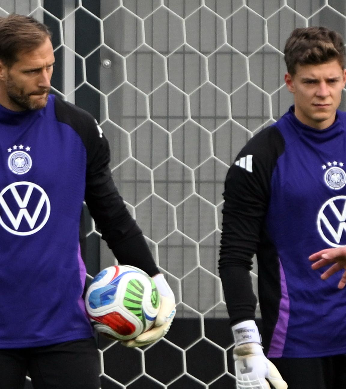 Torwarttrainer Andreas Kronenberg (l) spricht während des Trainings mit Torwart Oliver Baumann und Torwart Finn Dahmen